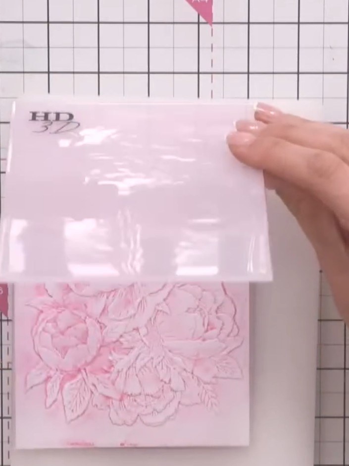 Step 5: Run the embossing folder with the inked design and your pink cardstock through the die-cutting machine to tran