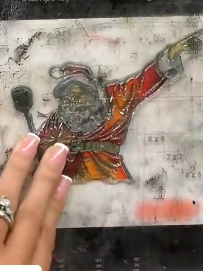 Step 8: Sprinkle gold embossing powder over the black stamped outline of the Santa image. Tap off the excess powder ba