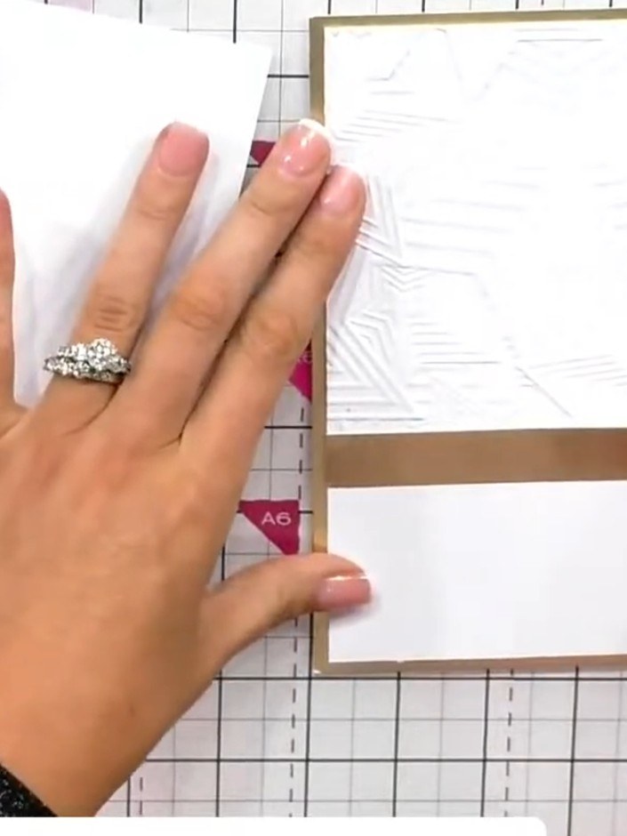 Step 8: Adhere the embossed white star panel to the kraft card base, positioning it off-centre in the upper portion of