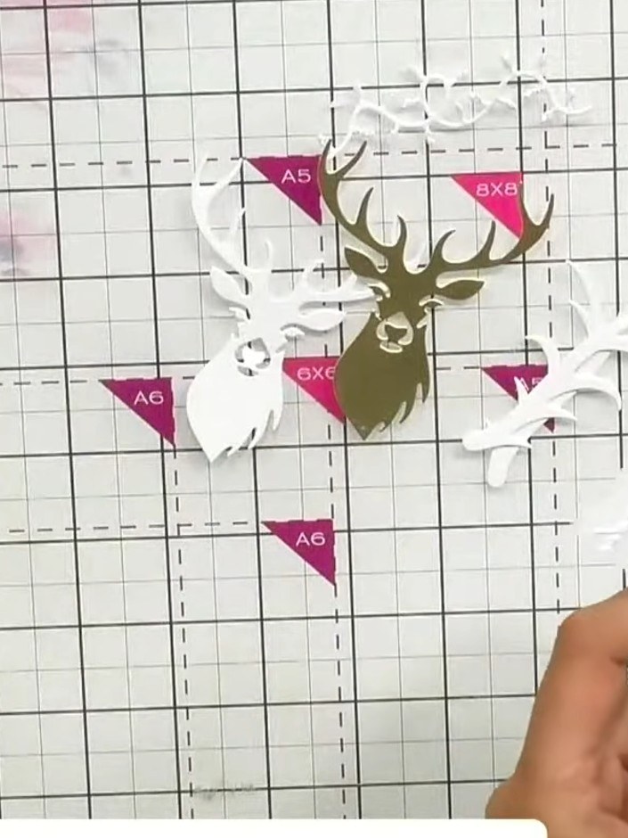 Step 5: Layer additional white antler die-cut pieces underneath the main gold antler to add dimension. Position white 