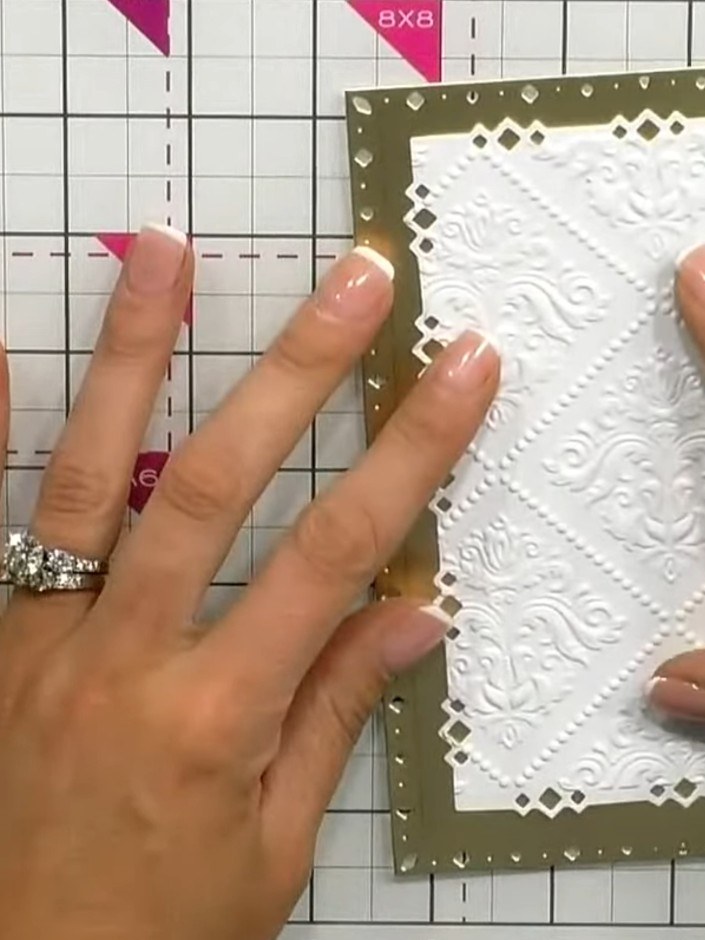 Step 6: Pega el panel blanco con relieve del ciervo en el centro del panel de fondo dorado con puntada de diamante.