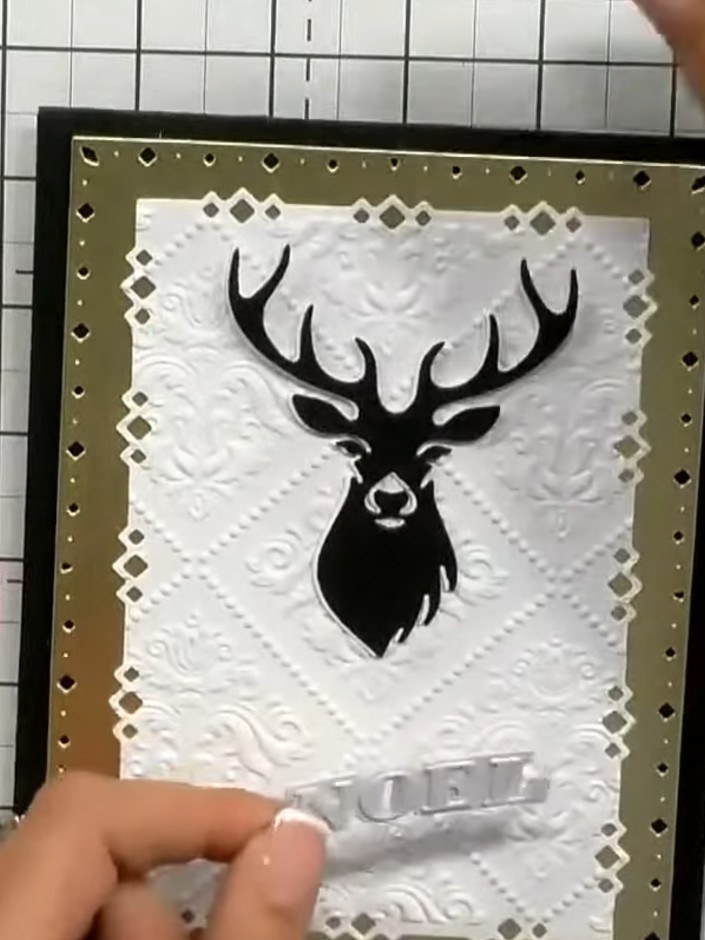 Step 8: Position the 'Noel' sentiment underneath the stag's body in the centre of the card. Keep the sentiment in a si