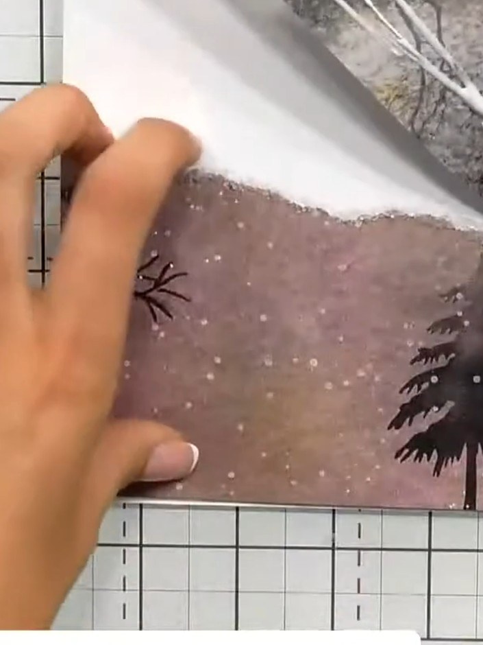 Step 6: Layer sparkled-edge paper pieces to create a simple landscape background suggesting hills. Position the pieces