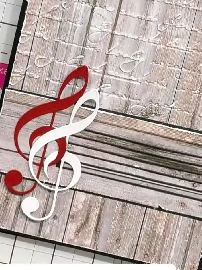 Step 4: Arrange the musical note die cuts on your card. Position the treble clef notes and music staff elements to cre