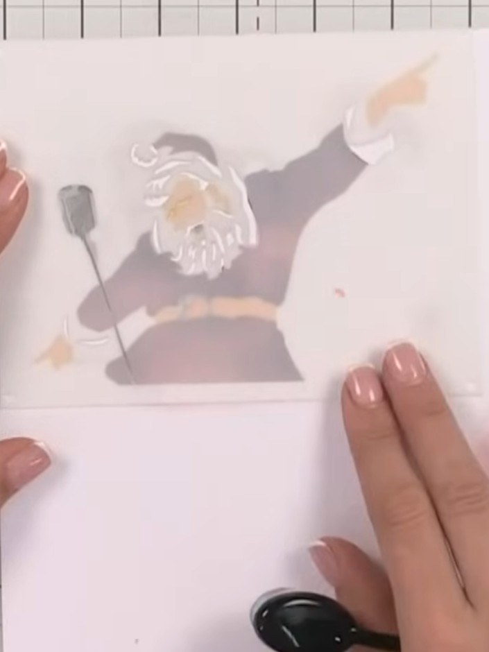 Step 6: Use the fourth stencil with light grey ink to add white-looking details to Santa's beard and the cuffs of his 