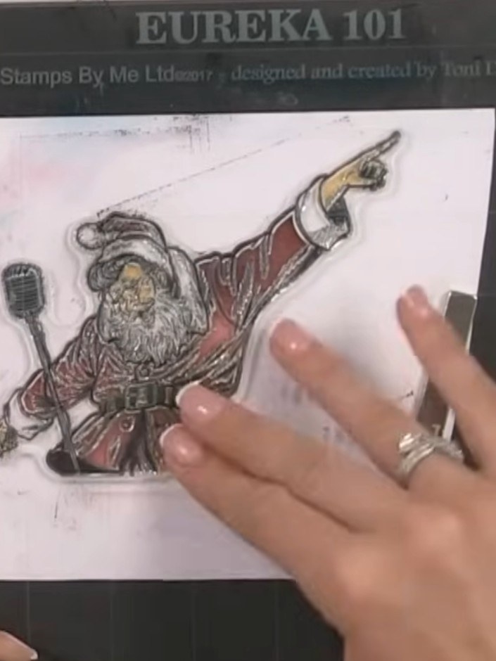 Step 8: Run the stamped Santa image through the 3D embossing folder, carefully lining it up to create texture in his b