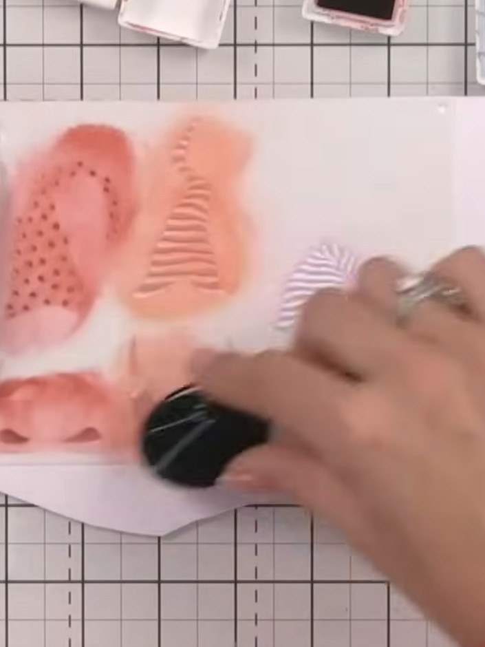Step 7: Using stencil two, apply orange ink to create spots and feet for the second gnome. Repeat the process with tea