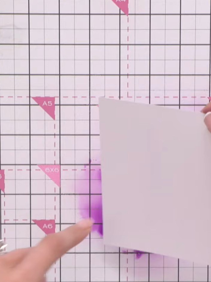 Step 1: Prepara una tarjeta base A2 o un trozo de cartulina blanca. Apply purple ink to the cardstock using a blending tool,
