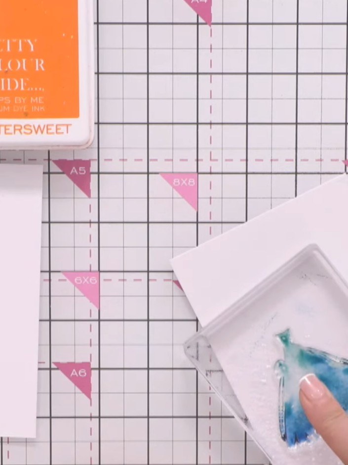 Step 4: Press the wet stamp onto your first piece of white cardstock, holding it in place to allow the blue ink to tra