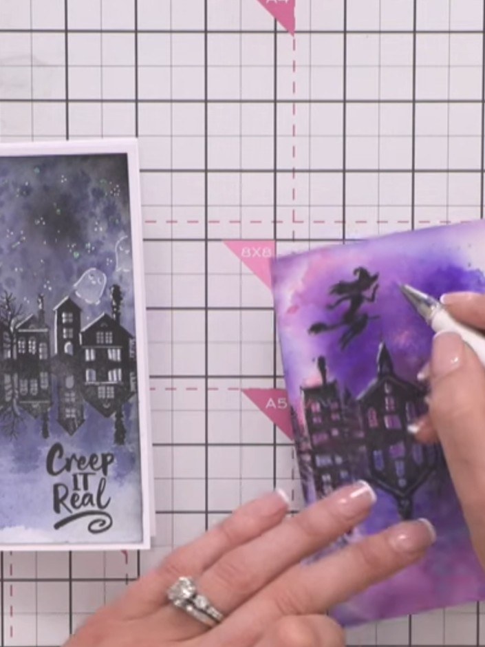 Step 8: Use a white gel pen to add highlights to the trees and the witch silhouette, creating dimension and making the
