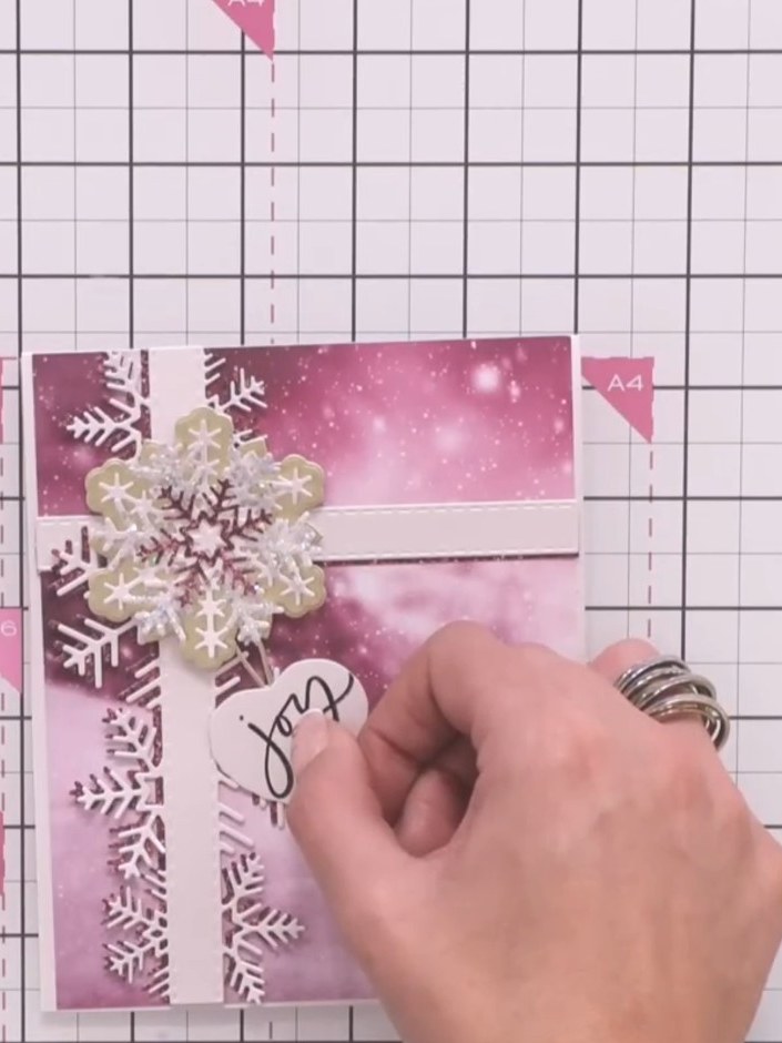 Step 10: Deja que el pegamento se seque por completo antes de exhibir tu tarjeta terminada. The snowflake embellishments and sentim