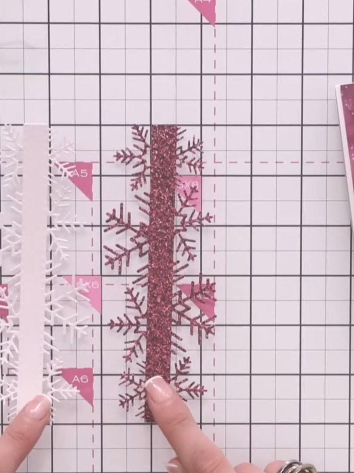Step 4: Layer the sparkly pink snowflake border on top of the white matte snowflake border. Use a small drop of glue t