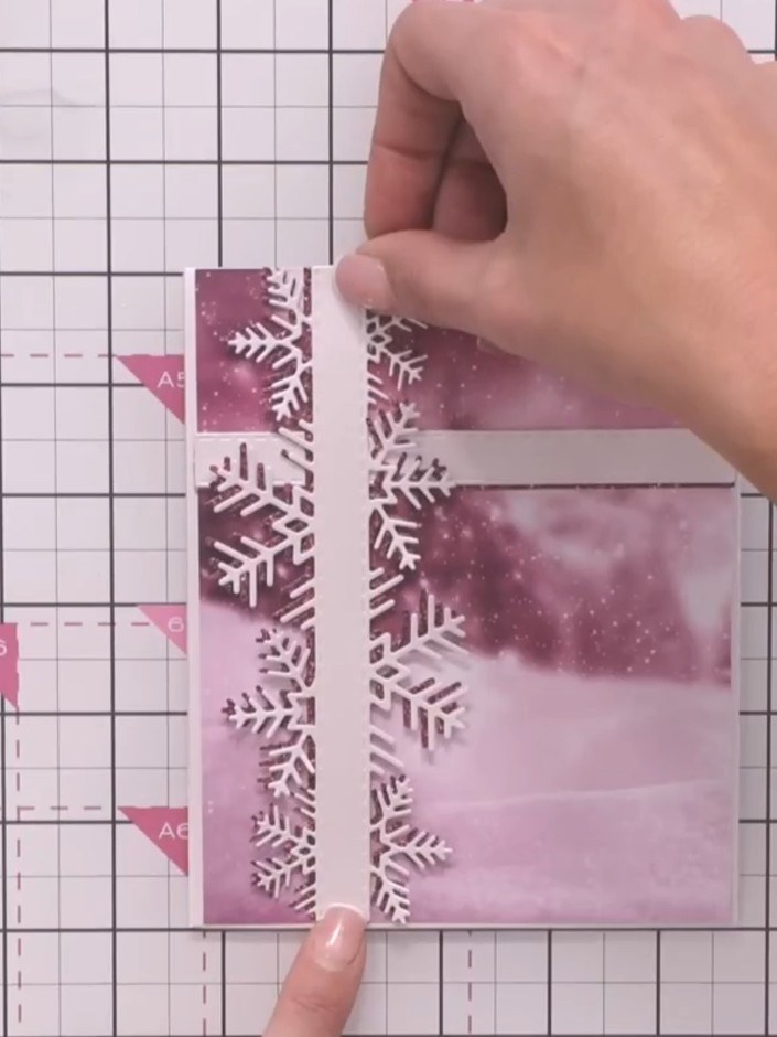 Step 7: Create a 3D snowflake embellishment by layering three die-cut snowflakes in graduating sizes. Stack them with 