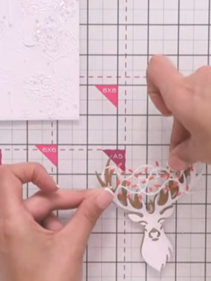 Step 11: Position and glue the light-coloured antler pieces into the gaps between the kraft antlers, tucking them in to