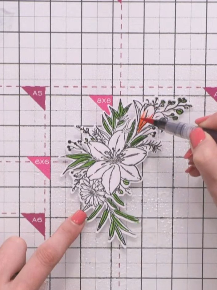 Step 10: Stamp and die-cut a second floral element using red cardstock. Colour the stamped image with orange and red wa