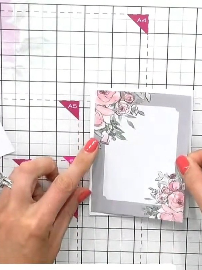 Step 1: Toma uno de los toppers florales en gris carbón y pégalo plano sobre cartulina blanca con adhesivo.