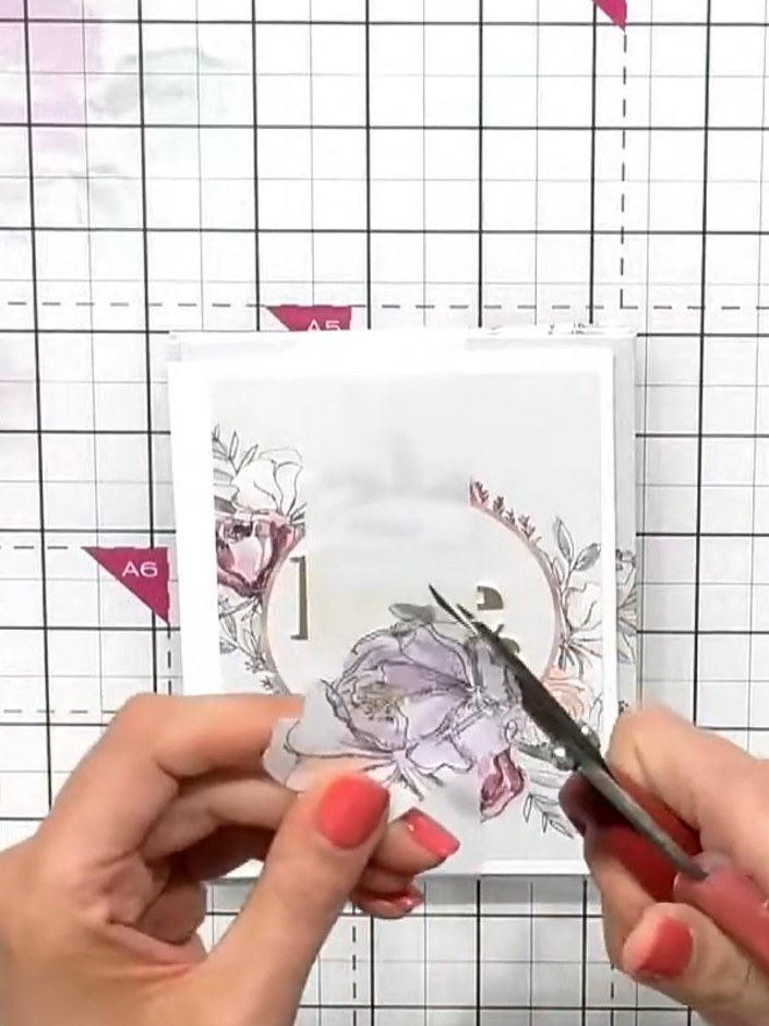 Step 7: Fussy cut a small floral element from the card topper sheet using scissors. This will be used to hide the tape