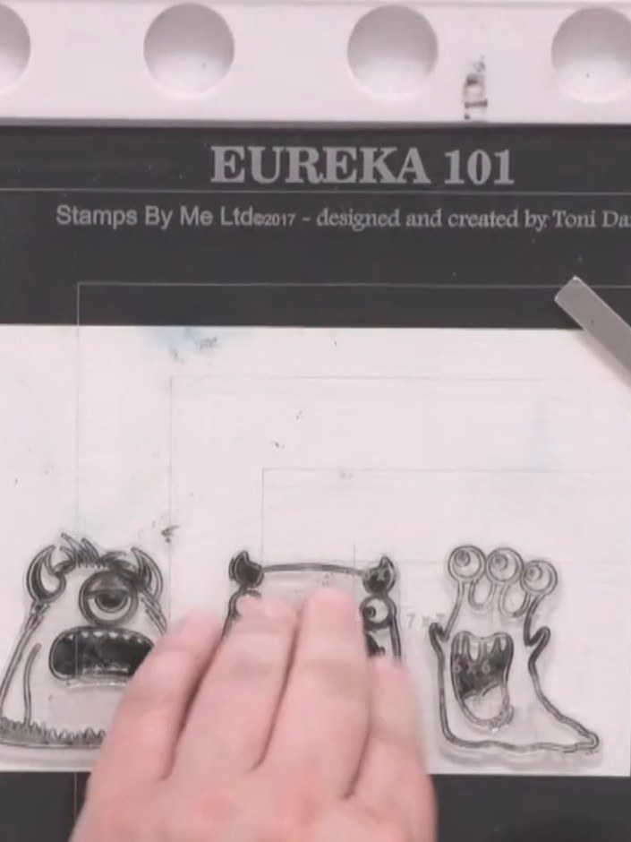 Step 3: Apply sticky embossing pad generously over the monster stamps, pressing firmly to ensure full coverage of all 