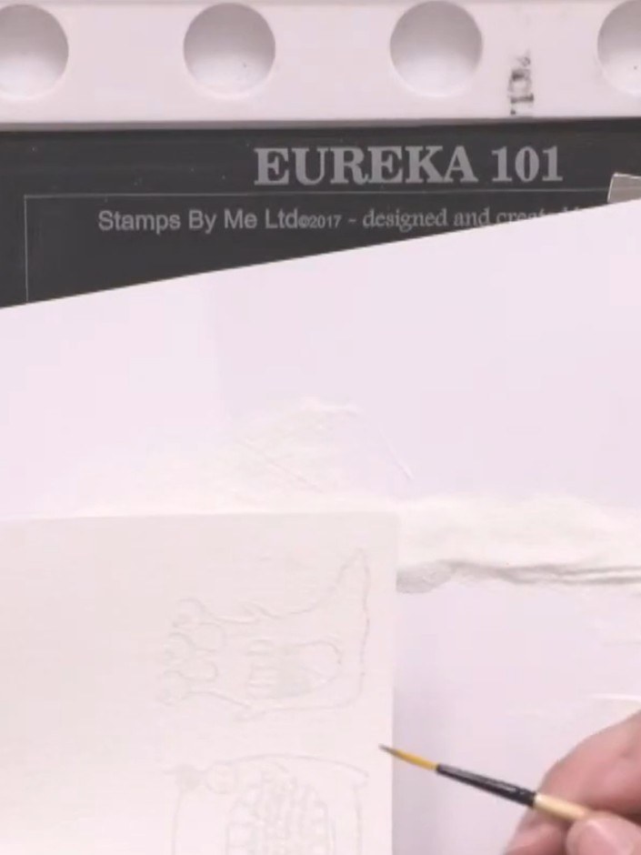 Step 5: Tap off the excess embossing powder from the card. Use a small brush to carefully brush away any unwanted powd