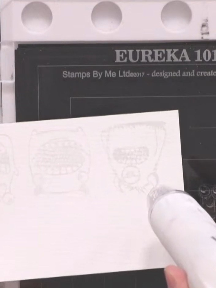 Step 6: Heat set the white embossing powder with a heat gun, moving it gently over the stamped design until the powder