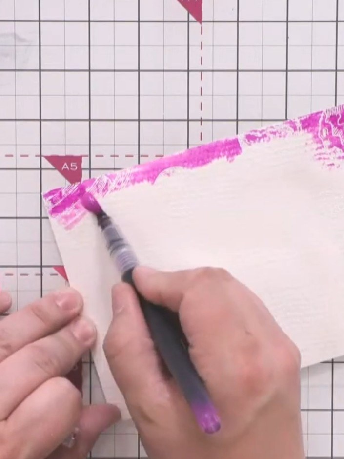 Step 9: Brush the purple watercolour pen across the wet areas at the top of the card, allowing the colour to blend and