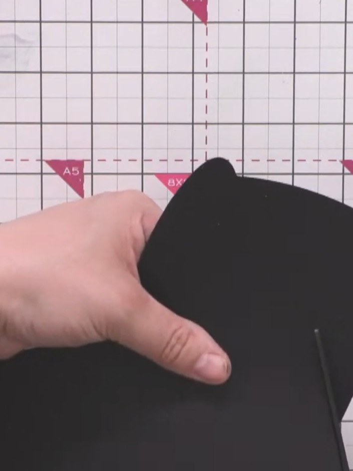 Step 11: Use scissors to trim away any excess black card that extends beyond the edge of the card blank, using the card