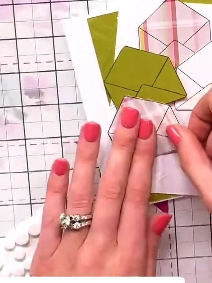 Step 7: Layer the pre-cut paper flowers and leaves together to create a dimensional bouquet. Position the bouquet arra