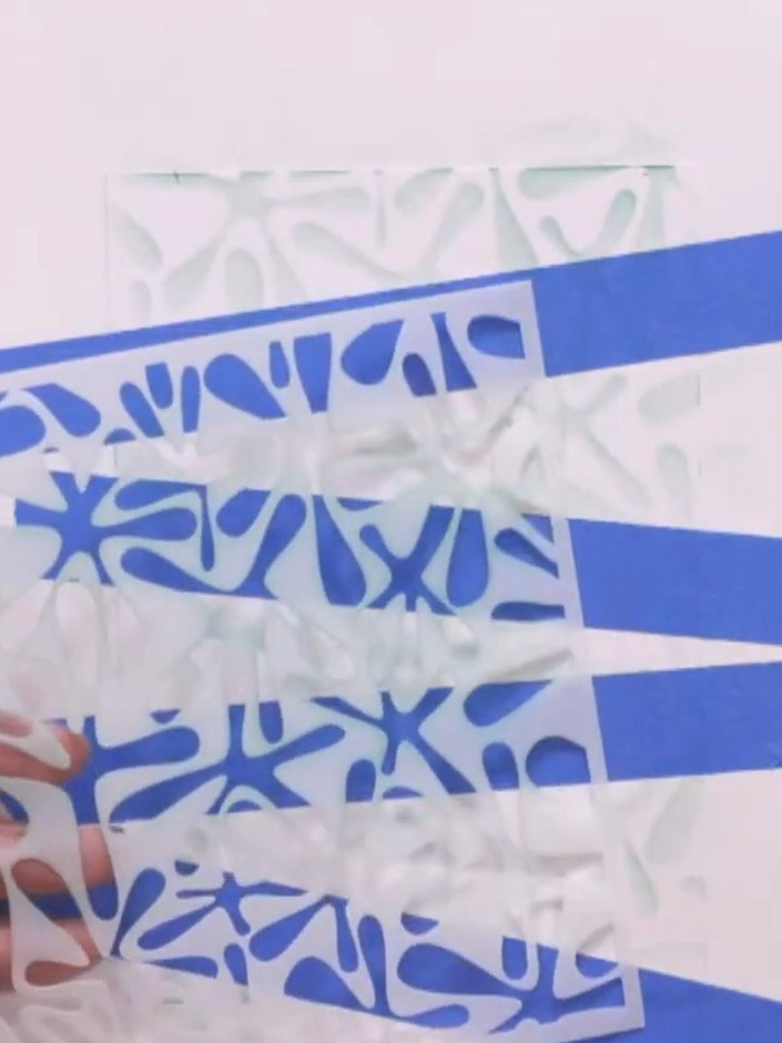 Step 5: Carefully peel away all the blue masking tape strips to reveal the white striped areas beneath where the stenc