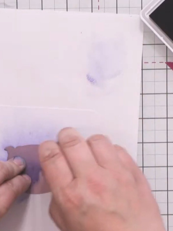 Step 6: Position the monster stencil over the white card panel and hold it firmly in place. Apply blue ink around the 