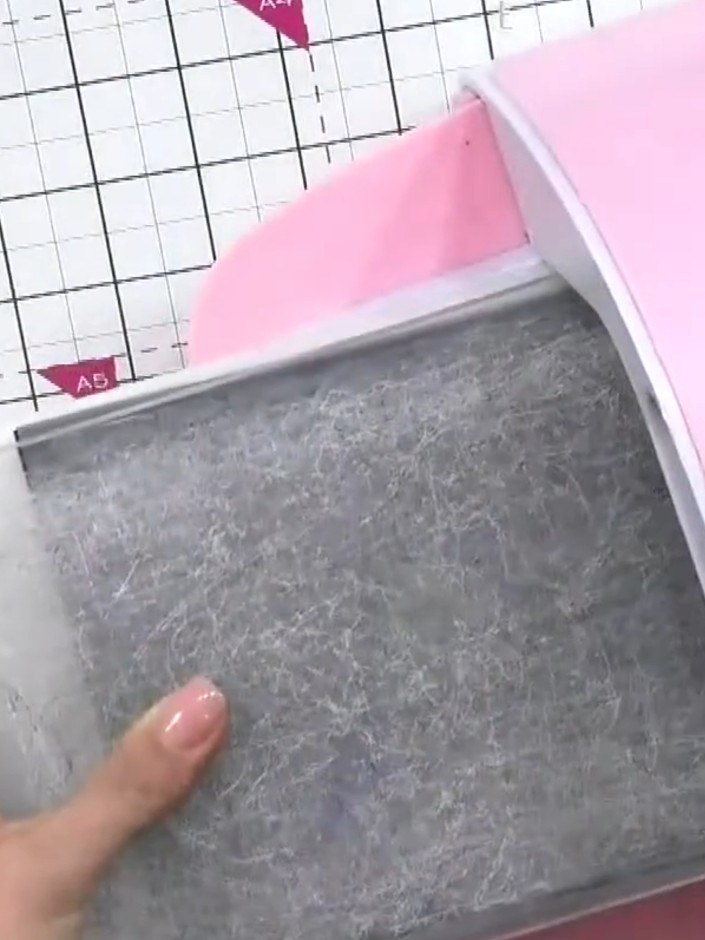 Step 2: Place your black cardstock onto the embossing platform with the Pebble Dash embossing folder. Run the cardstoc