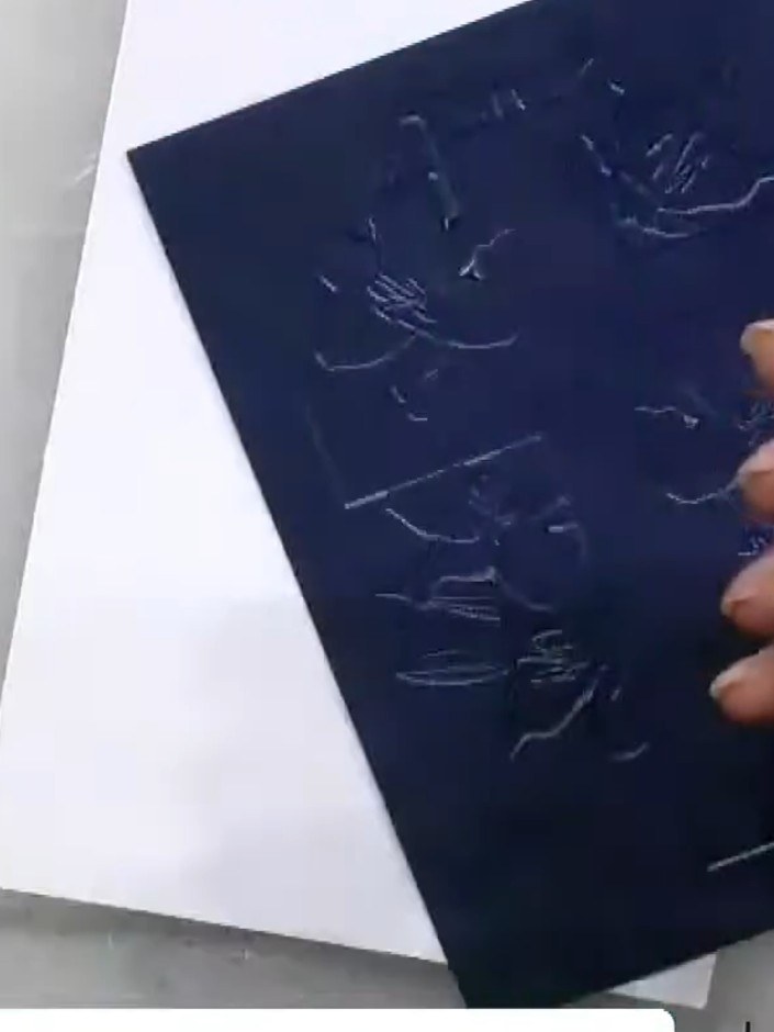 Step 3: Place your navy cardstock inside the embossing folder with the cross design. Run it through your die-cutting m