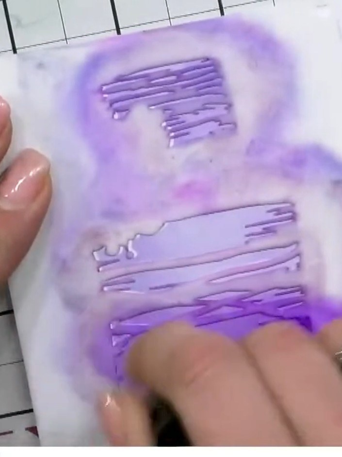 Step 4: Toma el segundo esténcil por capas (el número 2) y vuelve a alinearlo en la esquina. Apply purple ink through the 