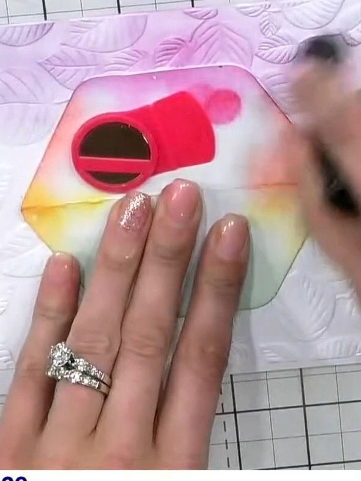 Step 6: Continue building the rainbow halo by applying yellow ink below the orange, then add green ink at the bottom. 