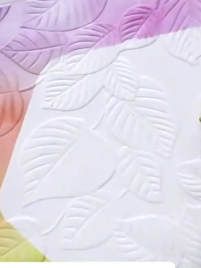 Step 7: Using a fine brush and gold confetti ink, carefully paint the raised leaf details within the embossed aperture