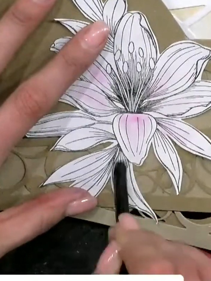 Step 6: Position the fussy-cut lily flower onto the front of the shaped card base. Use a brush to apply adhesive to th