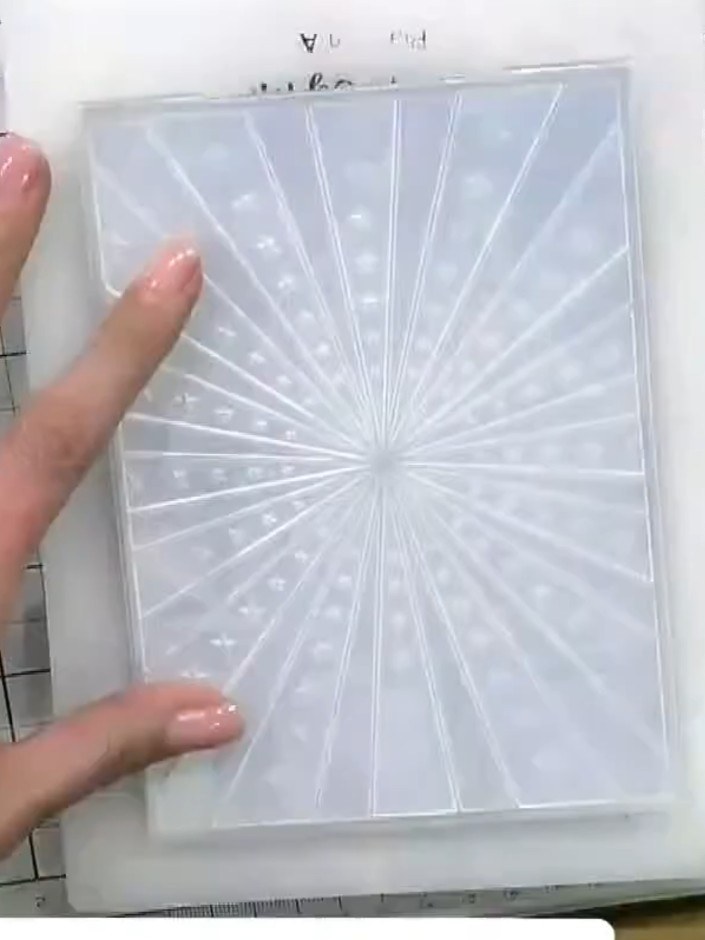 Step 1: Place the mirror board cardstock into the Stars embossing folder. Position the cardstock centrally within the 
