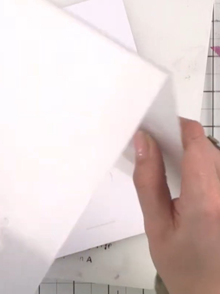 Step 4: Place your white card inside the embossing folder, positioning it carefully. Hold the folder open and slide th