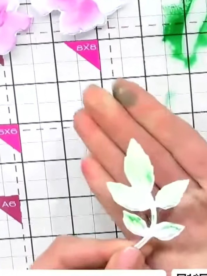 Step 5: Apply a darker green ink to the leaves using your finger, building up colour to create depth and variation. Ru