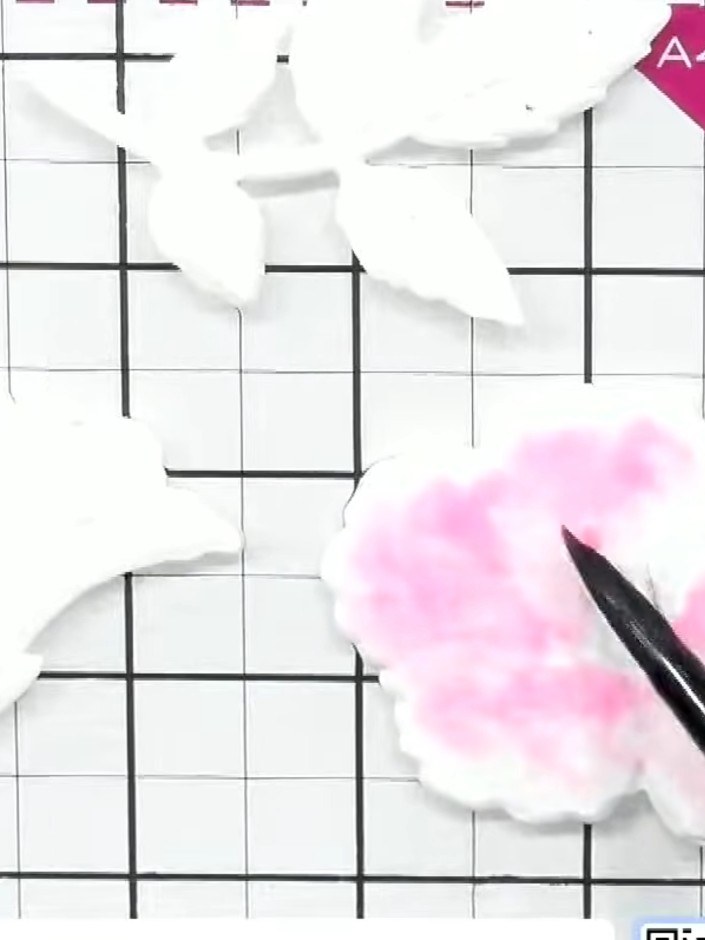 Step 3: Apply neon pink watercolour to the wet embossed flower petals using a fine brush, allowing the colour to sprea