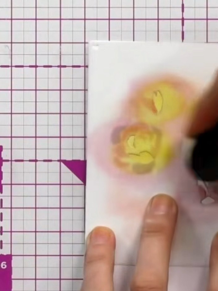 Step 2: Apply the third stencil using yellow ink to add variation and depth to the flower petals.