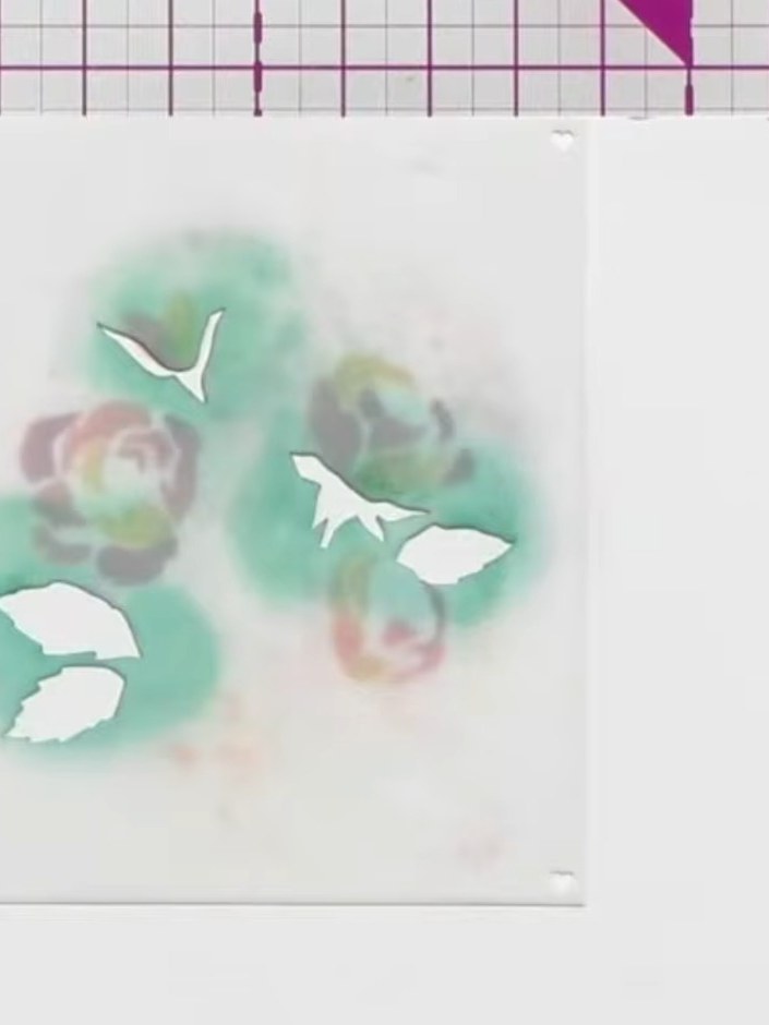 Step 3: Apply the fourth stencil to your card using green ink to create foliage and leaf details around the flowers.