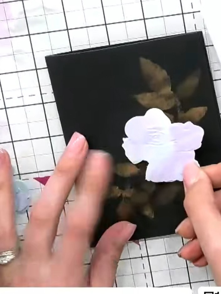 Step 3: Attach the first die-cut flower embellishment to the black card using foam tape for dimension. Position it tow