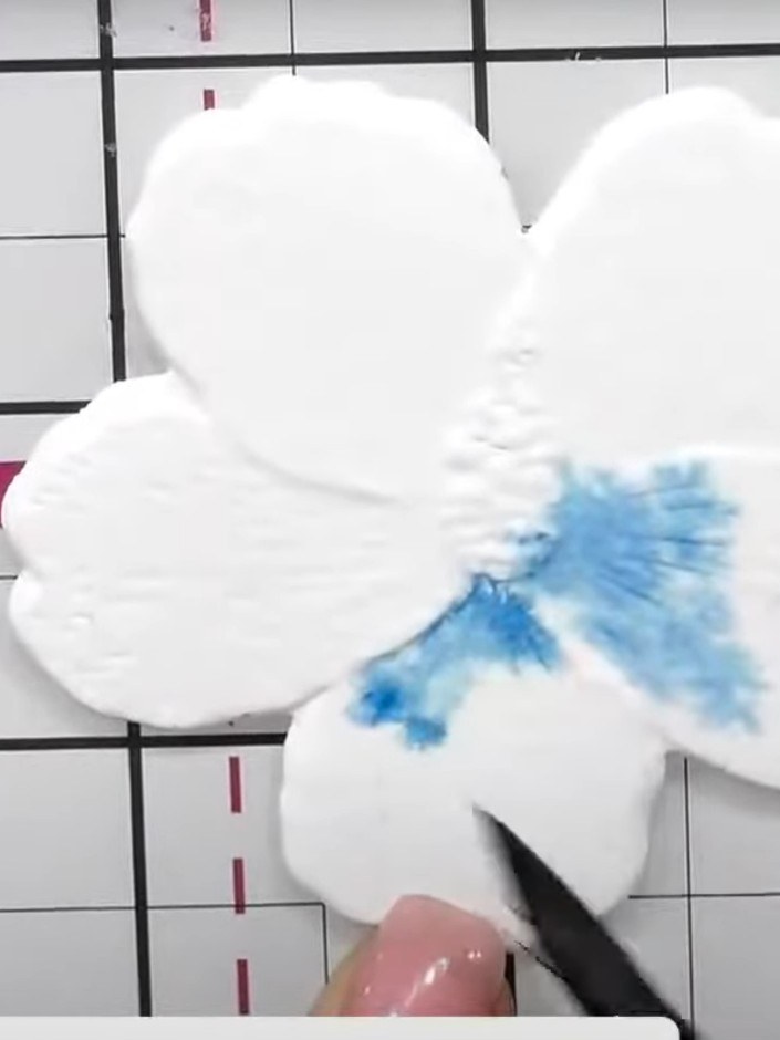 Step 4: Apply blue ink to the petals, leaving white spaces and a halo in the centre of the flower to create natural li