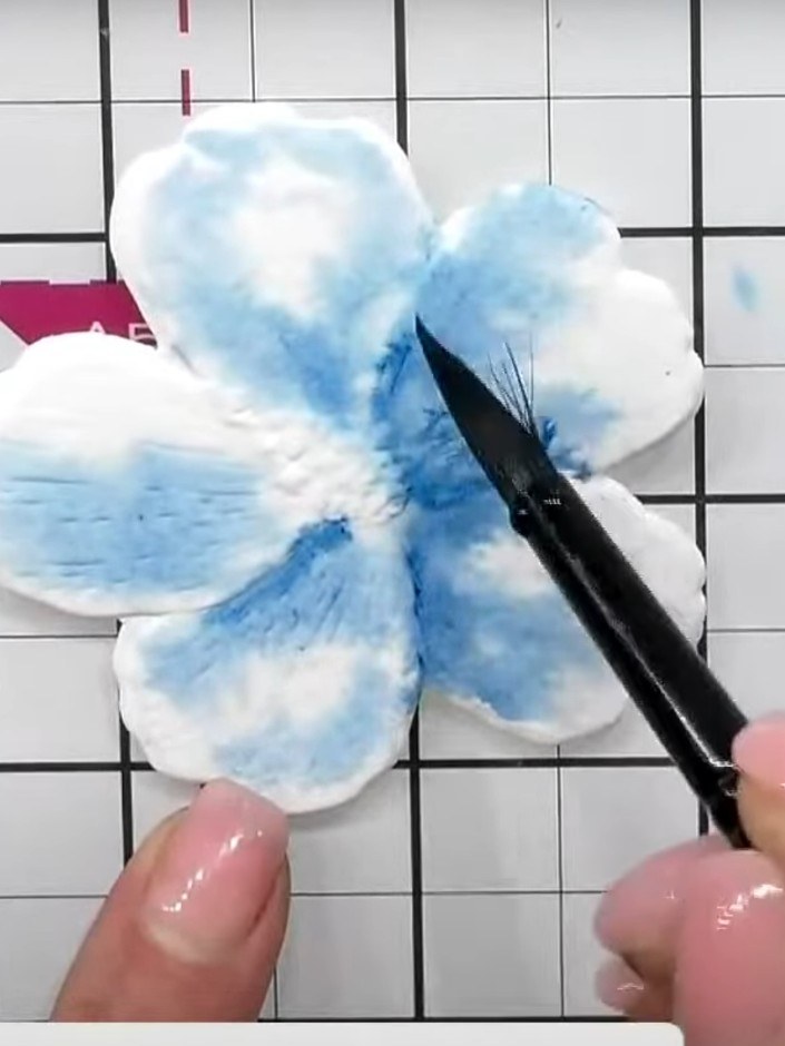 Step 7: If harsh lines form between the blue watercolour shades on the hibiscus petals, use a damp brush to pull water