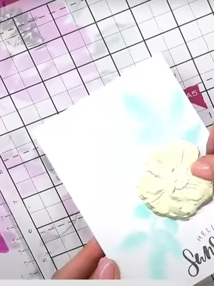 Step 2: Use the stencil from your embossing folder set to create a background on your card base. Apply colour through 