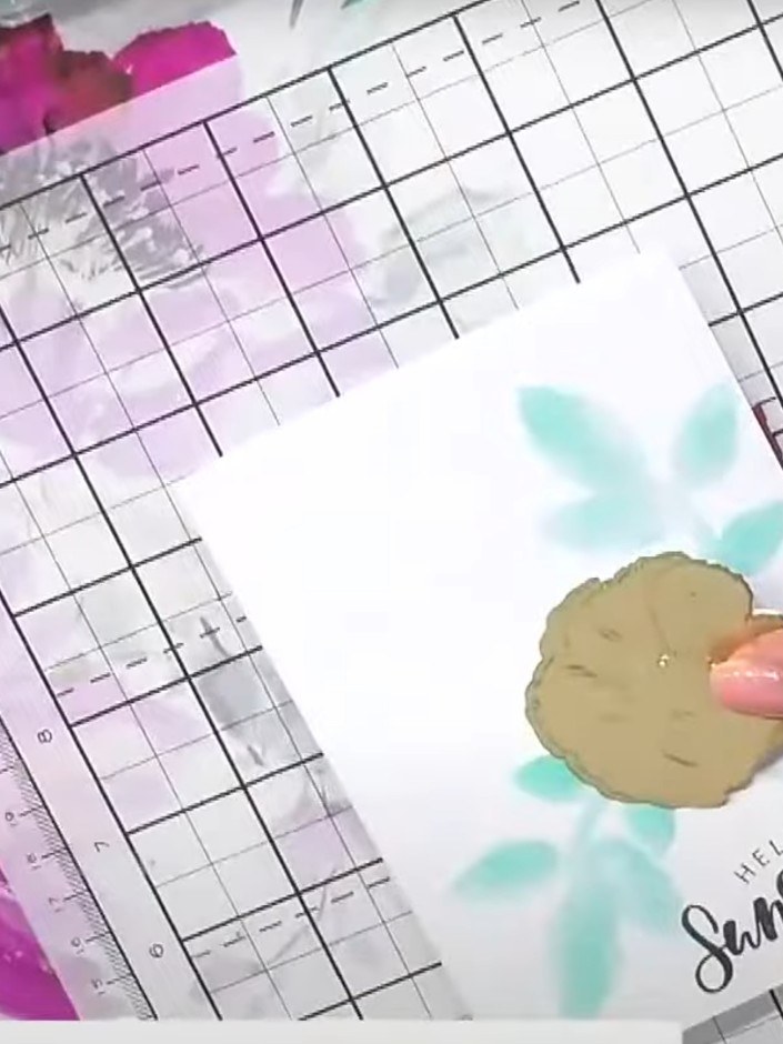 Step 3: Select one of the painted hibiscus embellishments and attach it to the centre of the card front using adhesive