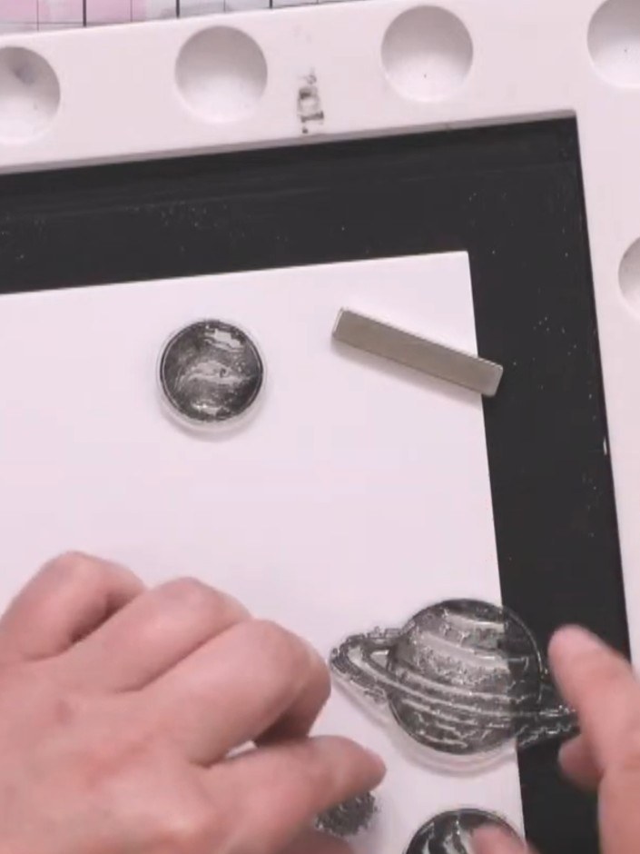 Step 1: Take a 7x7 inch card blank and randomly stamp the planet images across it using black ink. Position some stamp