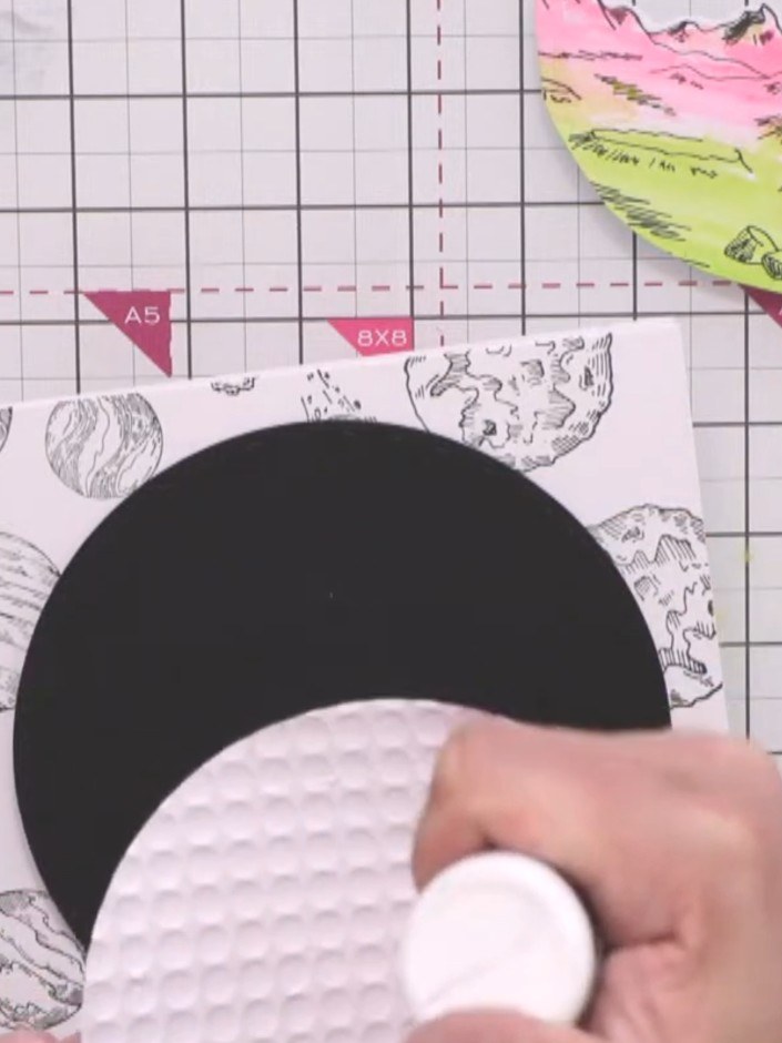 Step 10: Glue the white embossed circle to the black circle using a glue stick, ensuring it is centred. Then attach the