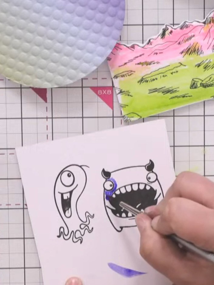 Step 6: Stamp the large monster character onto white card. Colour the monster using blue and purple watercolours. Heat