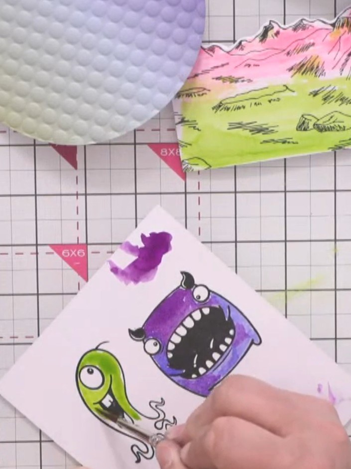 Step 7: Stamp the smaller monster character onto white card. Colour the green monster with vibrant green watercolour a